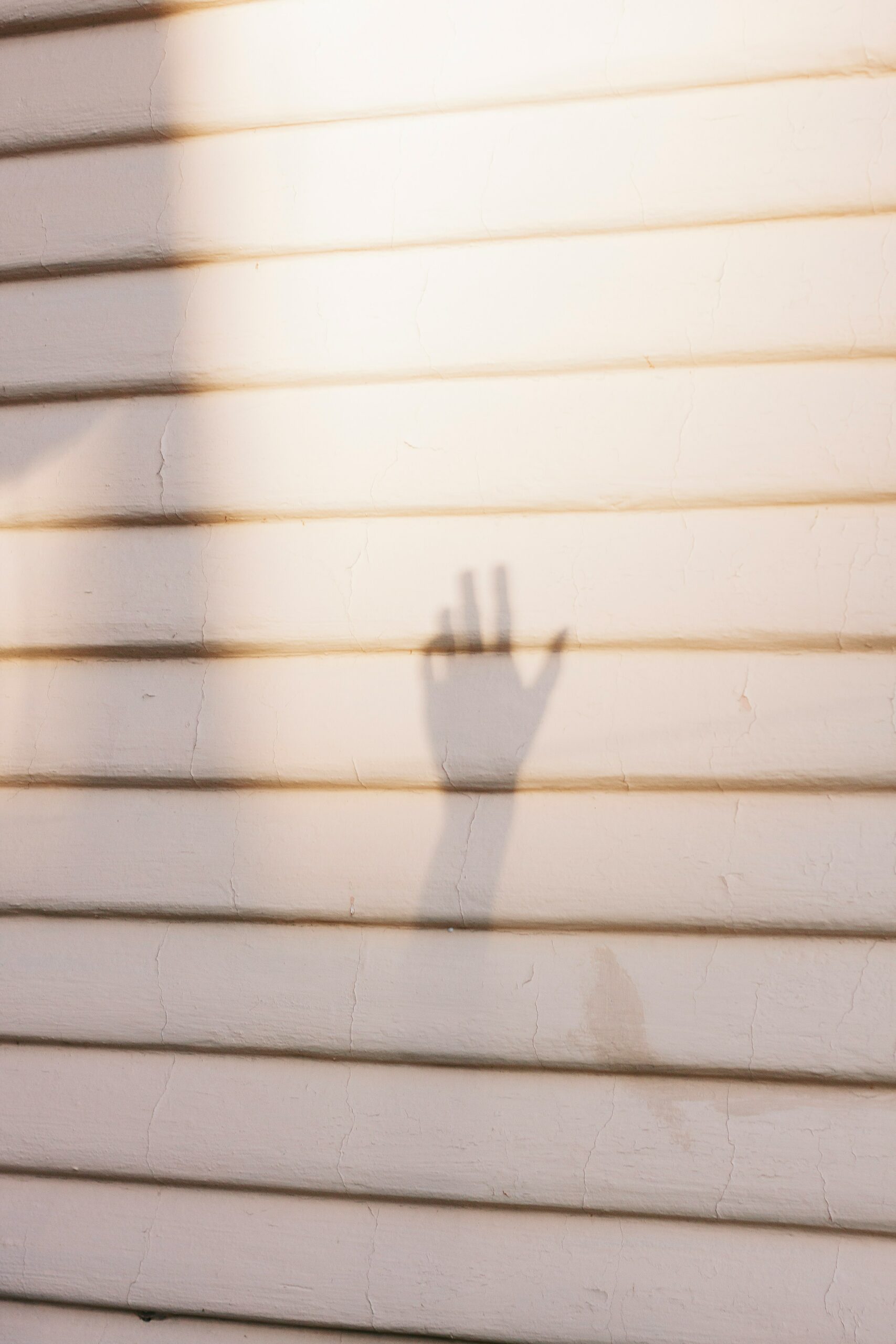 Hand taking a photo with a smartphone of a broken window for insurance claim evidence