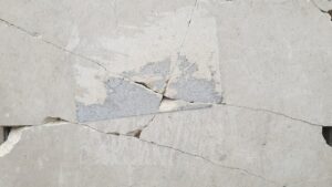 A close up of a piece of cement with a crack in it