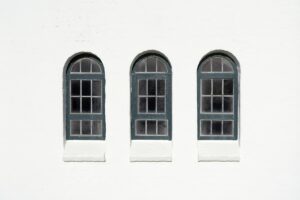 Three arched windows on a white wall
