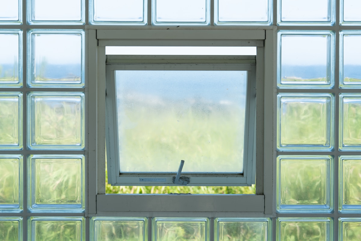 Open window in glass block wall overlooking landscape