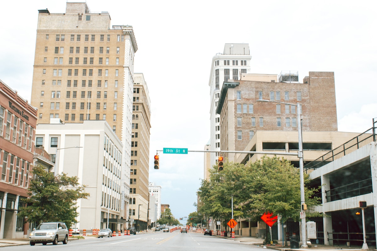 Paysage urbain avec gratte-ciel, feux de circulation et arbres.