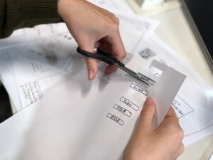 Mains tenant un stylo et remplissant un formulaire avec des options à cocher.