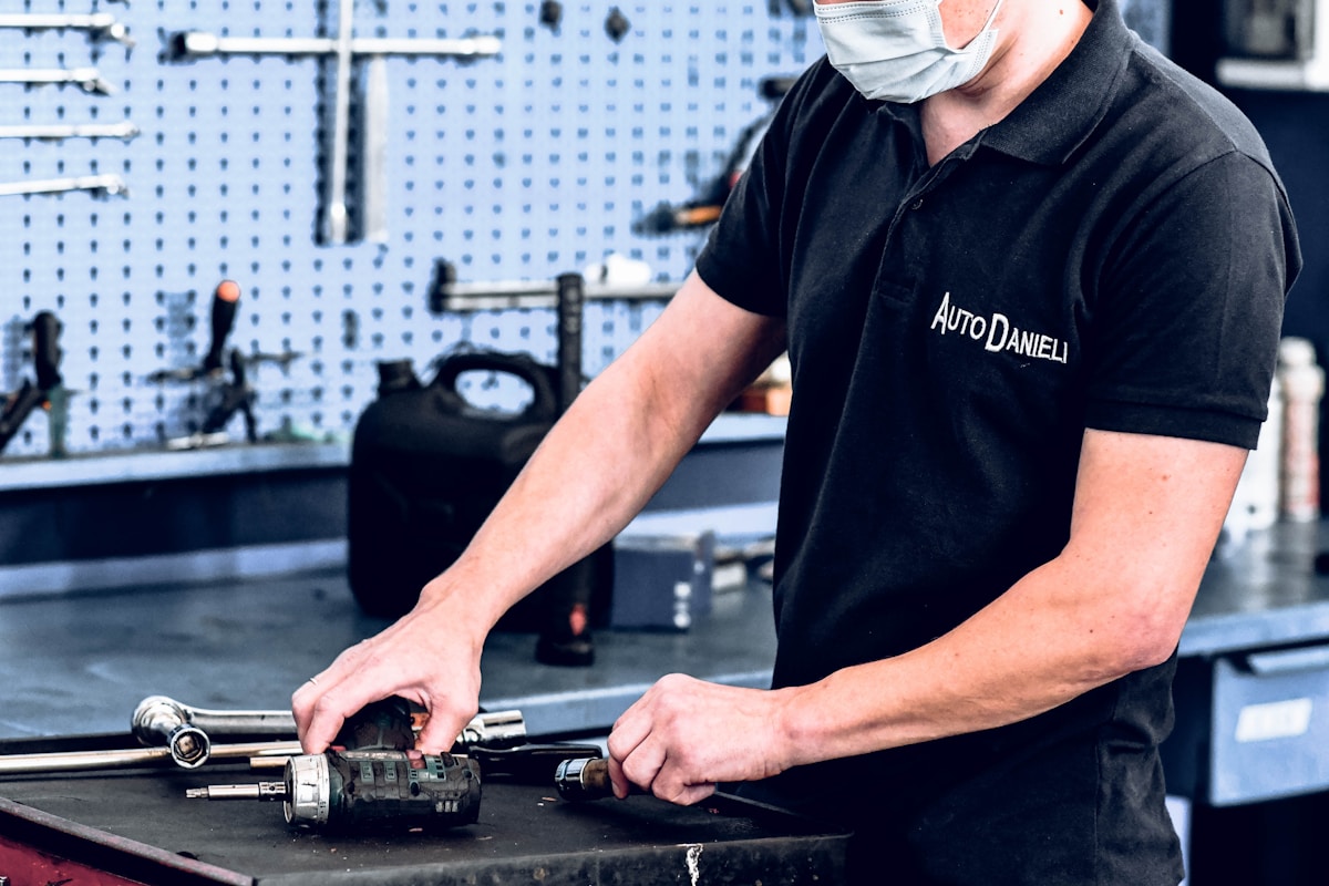 Mécanicien automobile en uniforme réparant un composant automobile.