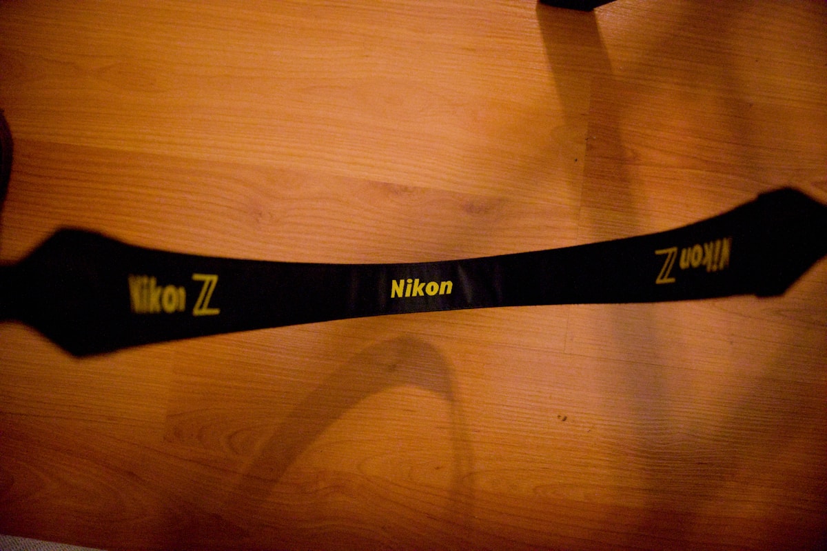 Sangle noire avec logo Nikon Z sur fond de bois.
