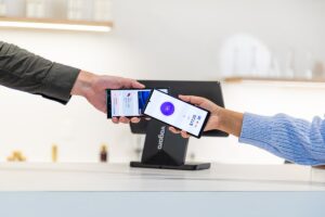 Deux personnes utilisant un terminal de paiement mobile pour effectuer un paiement.