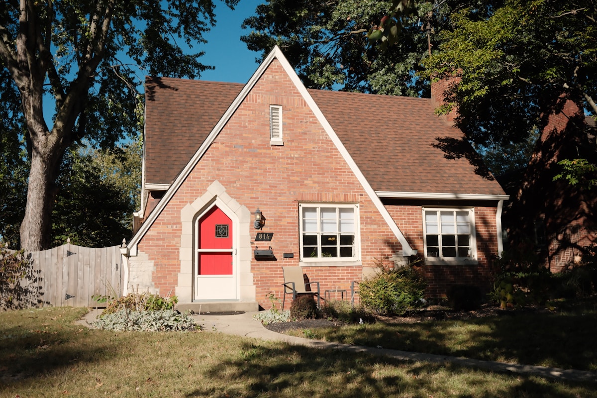 A charming brick house with a red door.