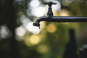 "Robinet en acier noir avec objectif tilt shift, signes de fuite d'eau cachée à Lille."