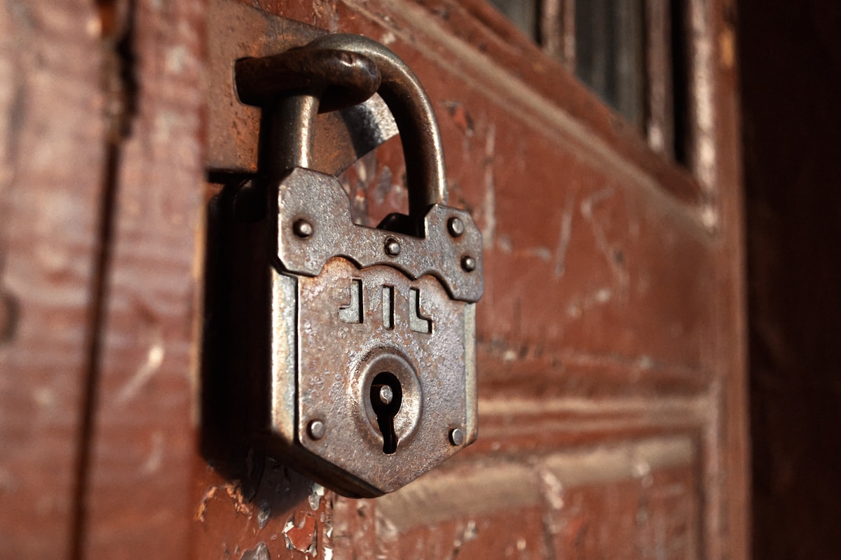 Cadenas rouillé en métal sur une porte en bois.
