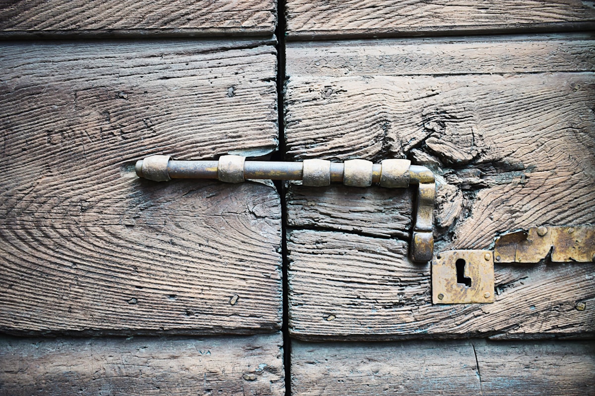 Vieille porte en bois avec verrou métallique rouillé.