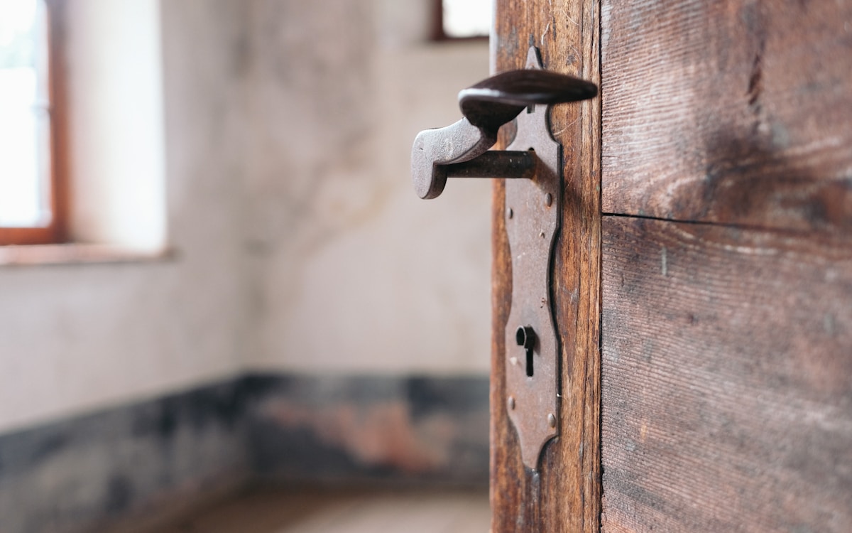 Vieille porte en bois avec gond métallique.