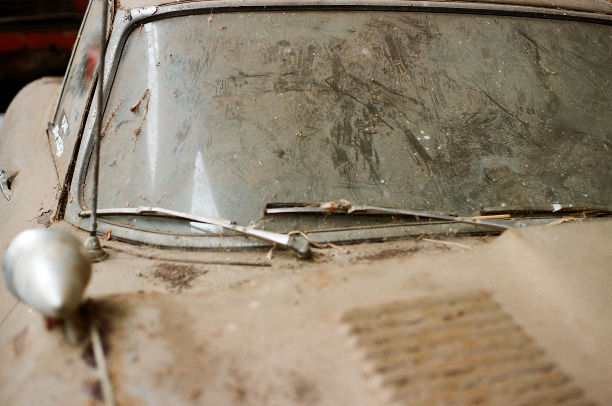 Vieille vitre de voiture endommagée et sale.