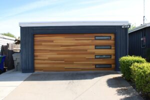 Porte de garage en bois et métal avec fenêtres.