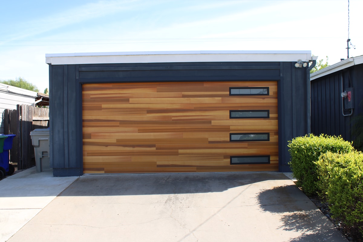 Porte de garage en bois et métal avec fenêtres.