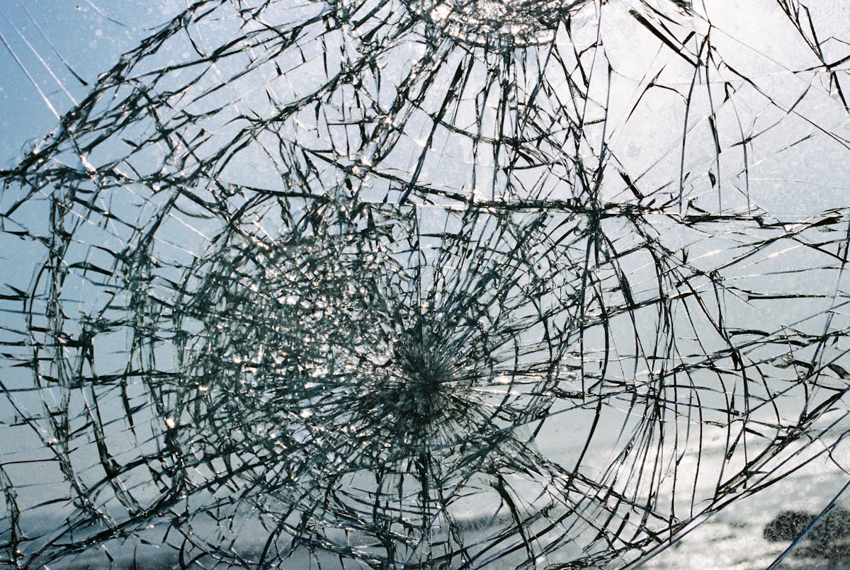 Verre brisé avec des fissures complexes et un motif radial.