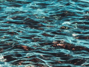 Vagues d'eau turquoise ondulantes avec des reflets dorés.