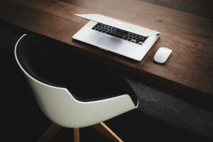 Bureau de travail avec ordinateur portable et souris sur une table en bois.